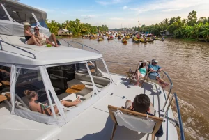 Guests on the foredeck passing a floating market